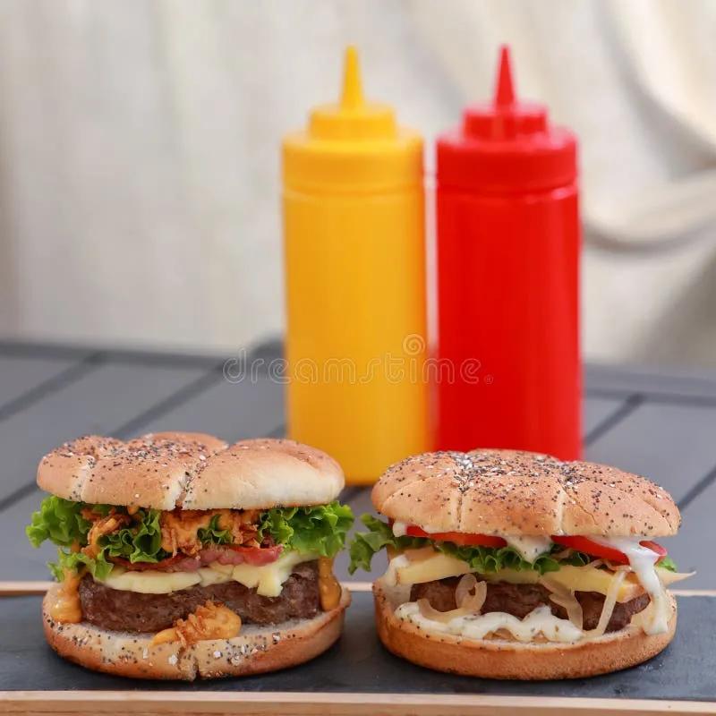 Two Hamburgers on a Table with Sauces on the Background Stock Image ...