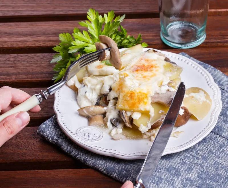 Kartoffelgratin mit Pilzen stockfoto. Bild von rustikal - 58904270