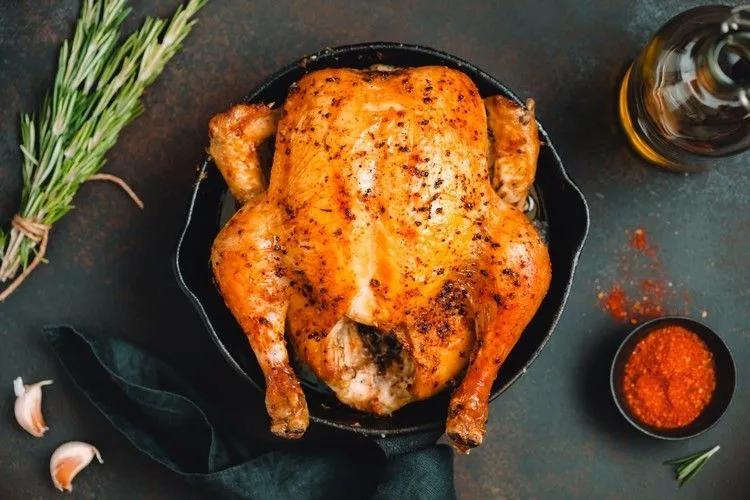 a roasted chicken in a cast iron skillet with spices and seasoning on ...