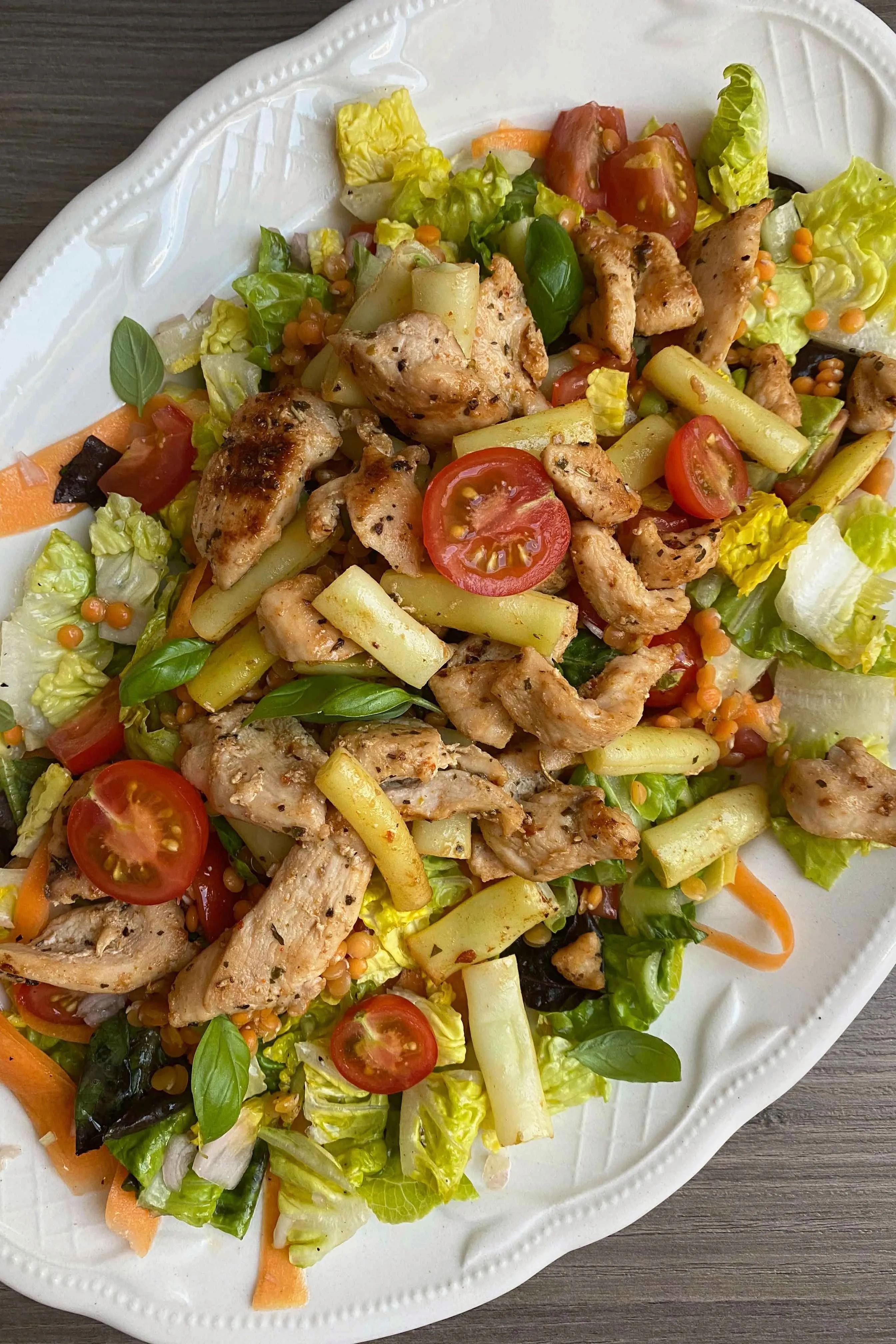 Ein frischer Salat mit warmen Hähnchenbrust-Streifen, roten Linsen und ...