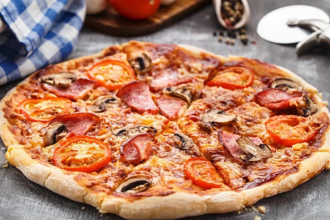 Pizza mit Tomaten, Schinken und Pilzen – Bilder kaufen – 12266571 StockFood