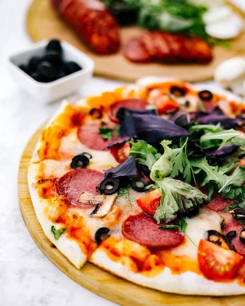 Die hälfte der peperoni-pizza mit oliventomatenpilz und kräutern ...