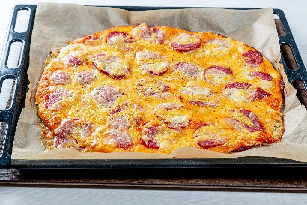 Große frische Pizza mit geräuchertem Wurst und Mozzarellakäse auf ...