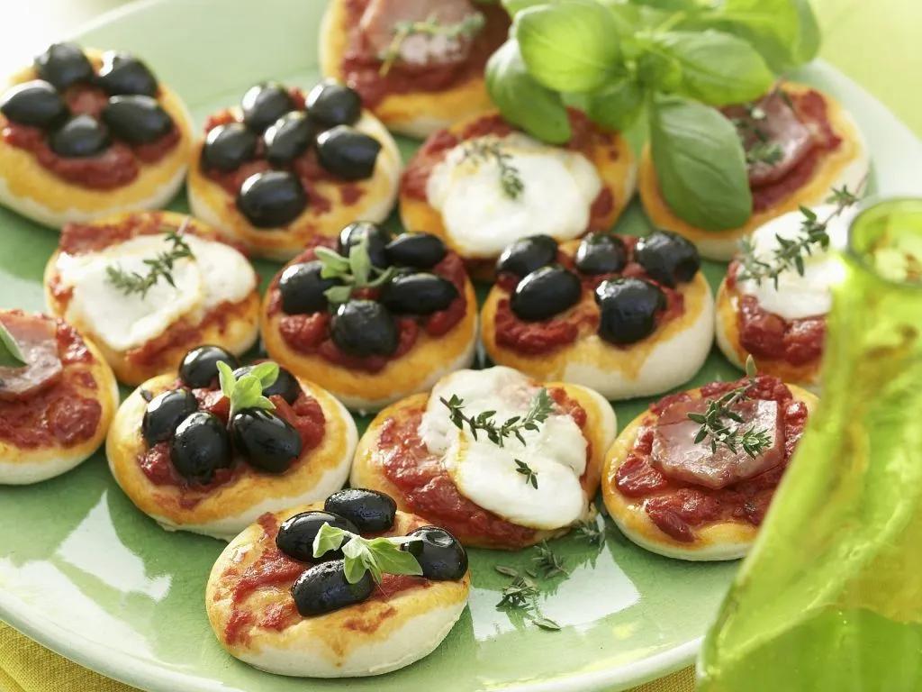 Kleine Pizza-Happen mit Olive, Mozzarella und Schinken Rezept | EAT SMARTER