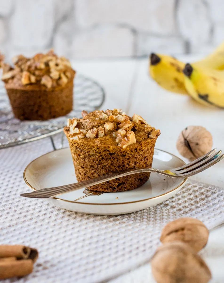 Glutenfreie Bananenmuffins mit Walnüssen und Zimt auf kleinem Teller ...