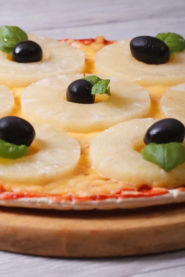 Pizza Mit Ananas Und Schwarzen Oliven Auf Der Alten Tabelle Stockbild ...