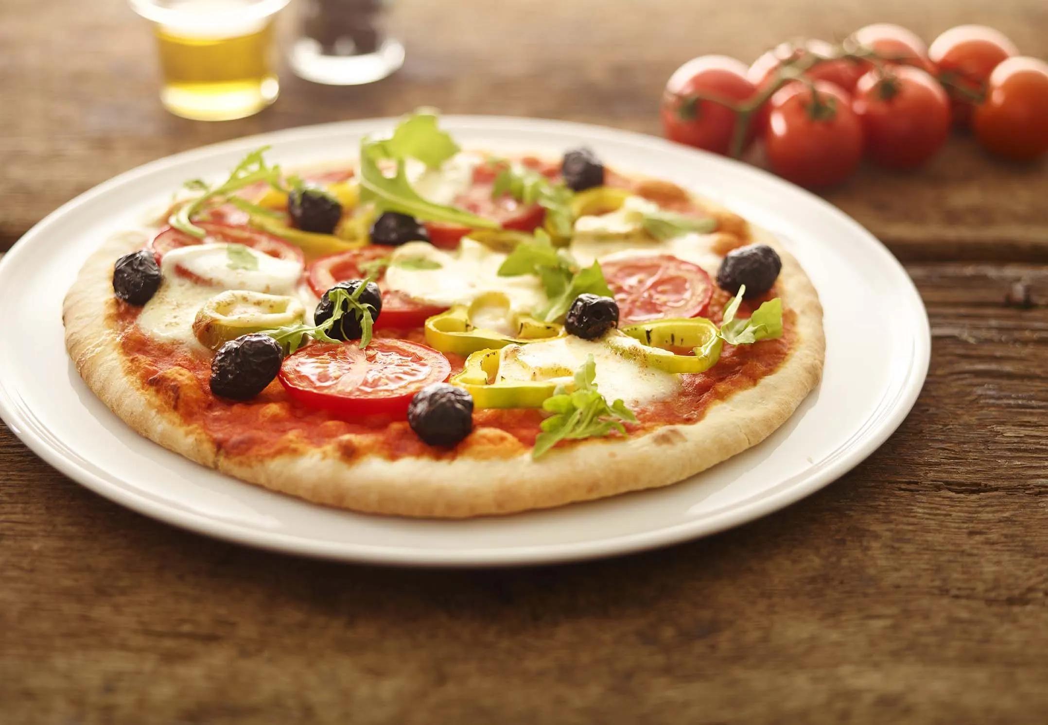 Pizza met tomaat, paprika, zwarte olijven en rucola... Allemaal op een ...