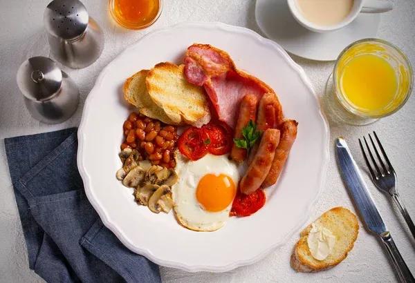 Englisches Frühstück Mit Spiegeleiern Würstchen Speck Bohnen Und Toasts ...