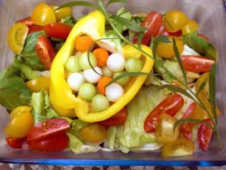 paprikaschiffchen gefüllt mit salatperlen auf bunten blattsalaten