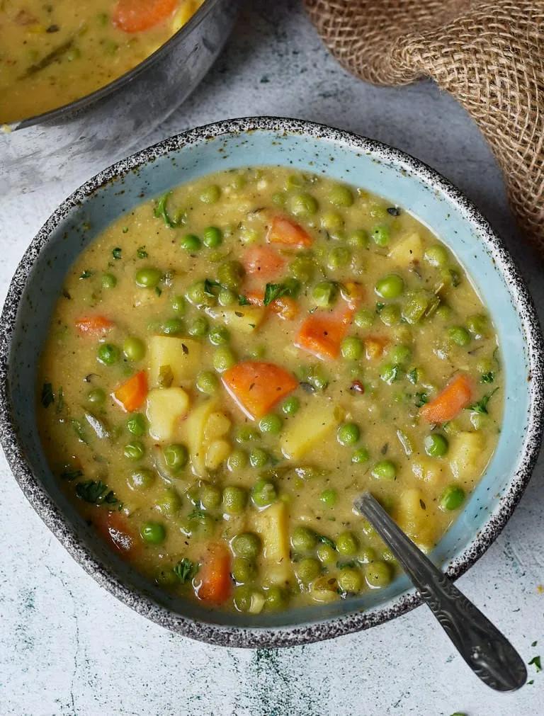 Diese herzhafte vegane Gemüsesuppe enthält grüne Erbsen, Kartoffeln ...