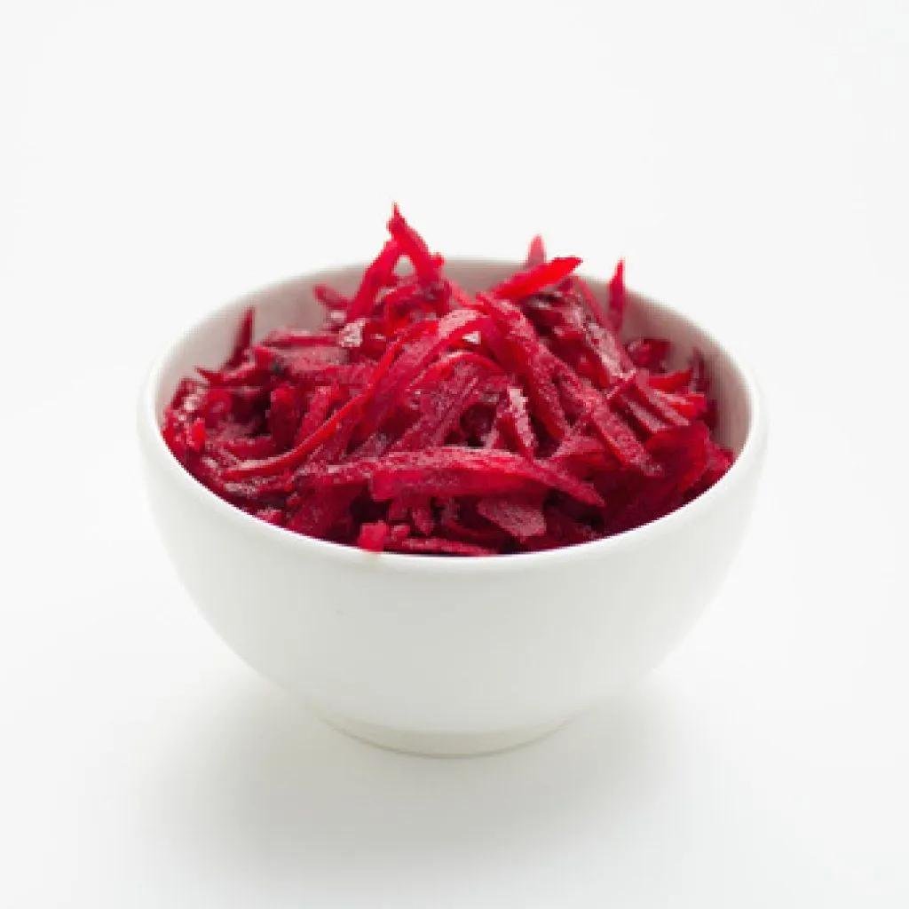 a white bowl filled with red food on top of a table