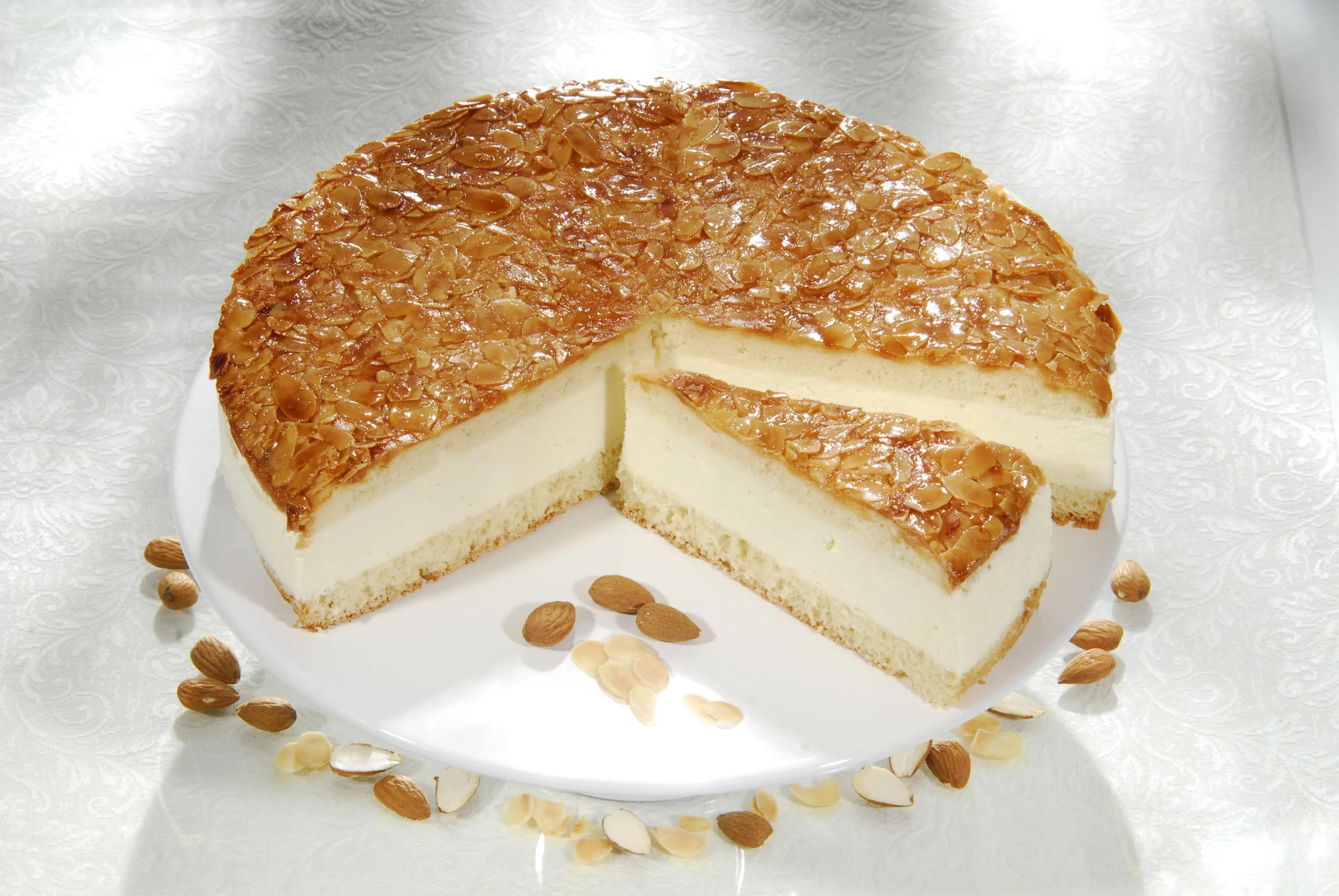 a white plate topped with a cheesecake covered in nuts
