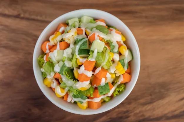 Gurkensalat, mais, karotte und salat in einer weißen tasse ...