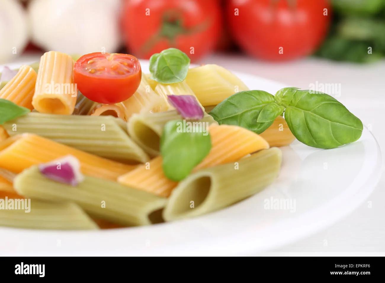 Bunte Penne Rigate Nudeln Pasta mit Tomaten und Basilikum auf Teller ...