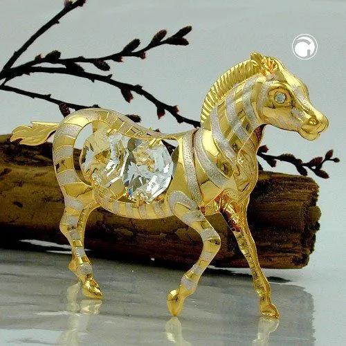a golden horse figurine sitting on top of a wooden branch next to a twig