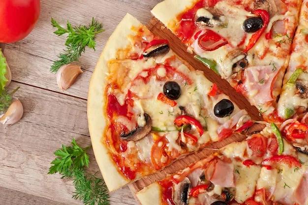 Pizza mit schinken, champignons und oliven | Kostenlose Foto