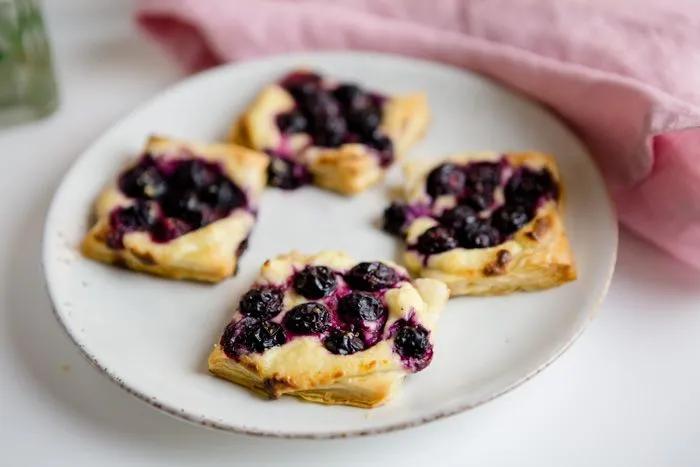 small pastries with blueberries on a white plate