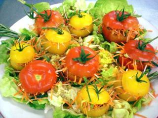 kopfsalat mit gefüllten gelben und roten tomaten