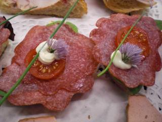 laugenbrötchenhappen mit mailänder salami und schnittlauchblüten