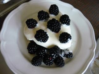 schokoladenkuchen mit vanillecreme glasur und brombeeren