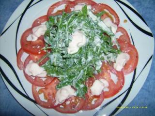 rucola mit scharfer quarksauce auf tomaten